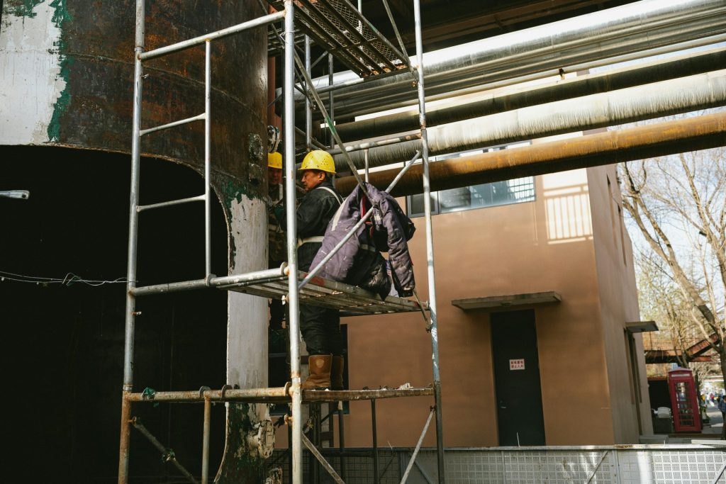 a man standing on a scaffold next to a building