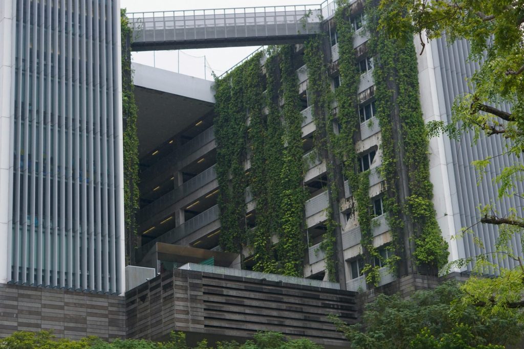 Bâtiment moderne avec jardins verticaux et passerelle aérienne